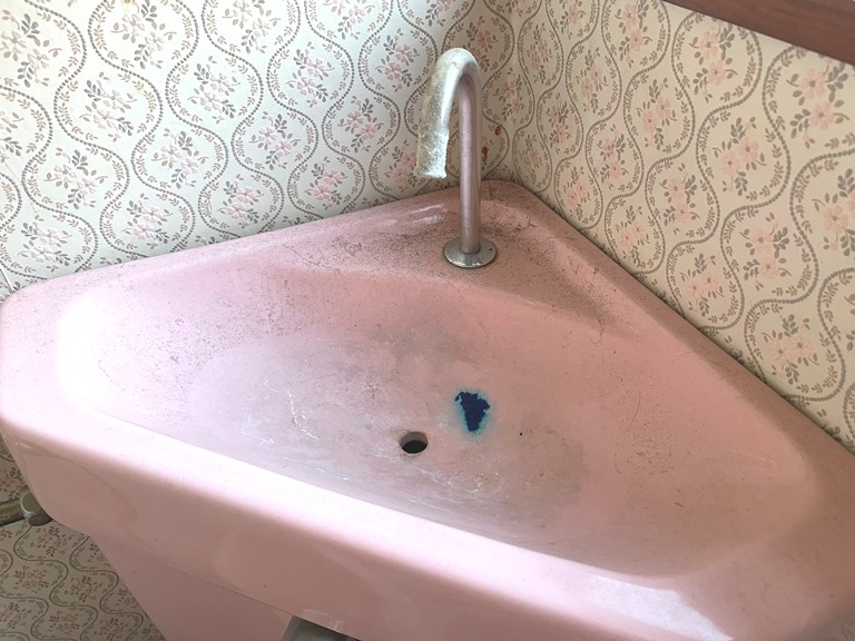 長年放置されて汚れが染みついた手洗い器