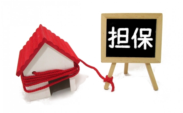 家の模型と担保と書かれたイーゼルの画像